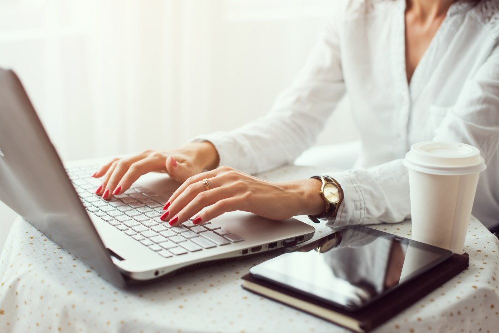 Woman working in home office hand on keyboard close up