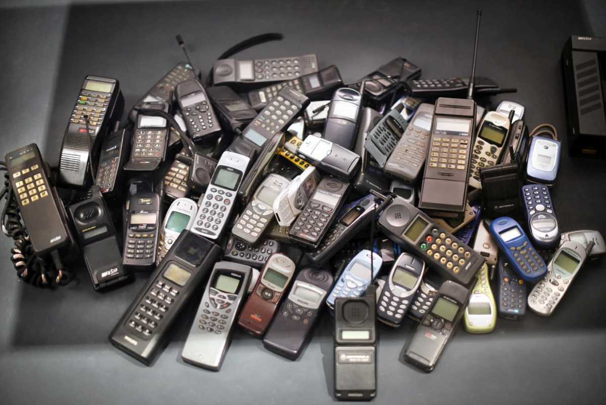 Stack of old vintage mobile phones on dark background